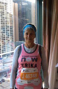 Woman in hotel room wearing running kit and race number
